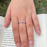 Hand wearing a ring with a small flower design 