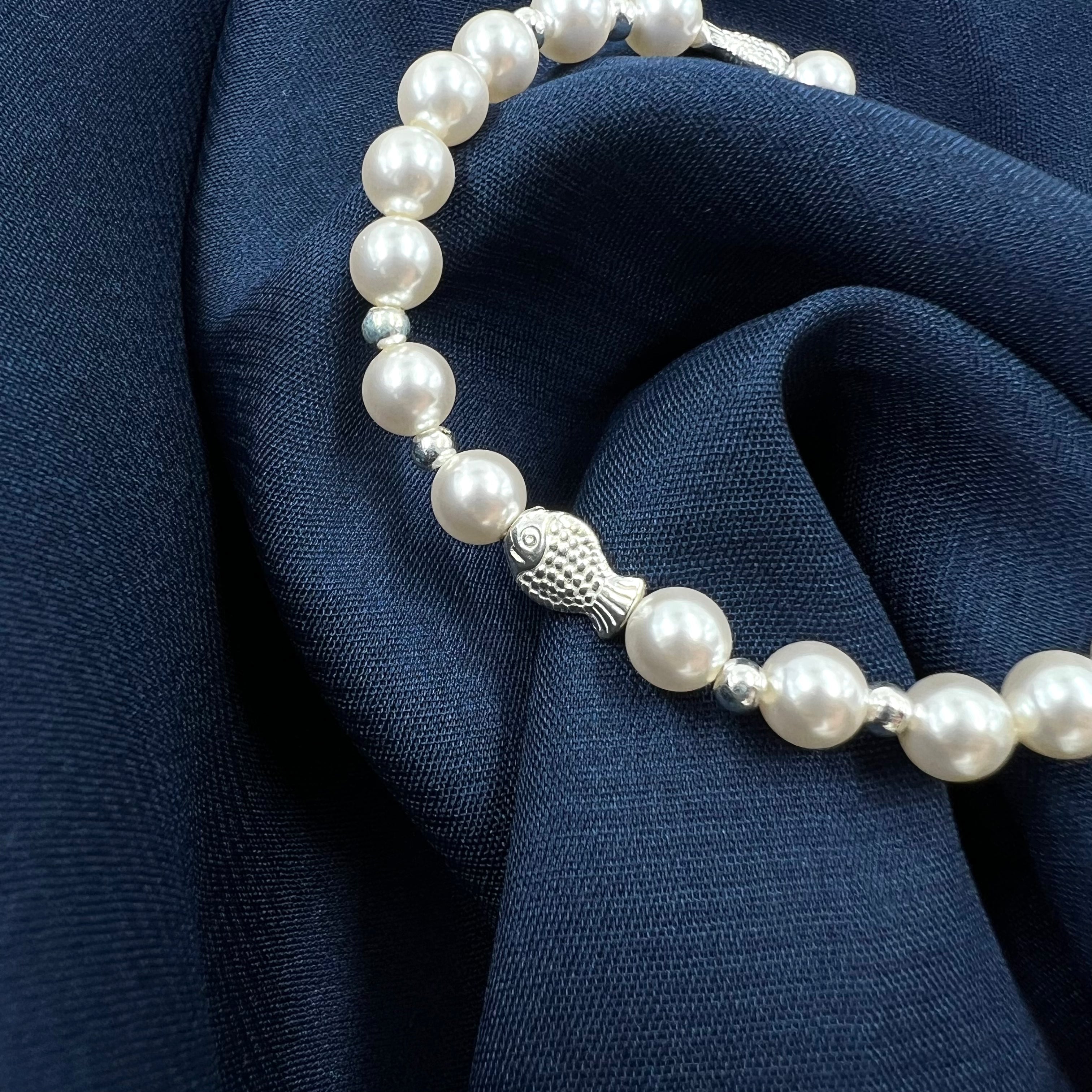 Pearl bracelet with silver fish charm