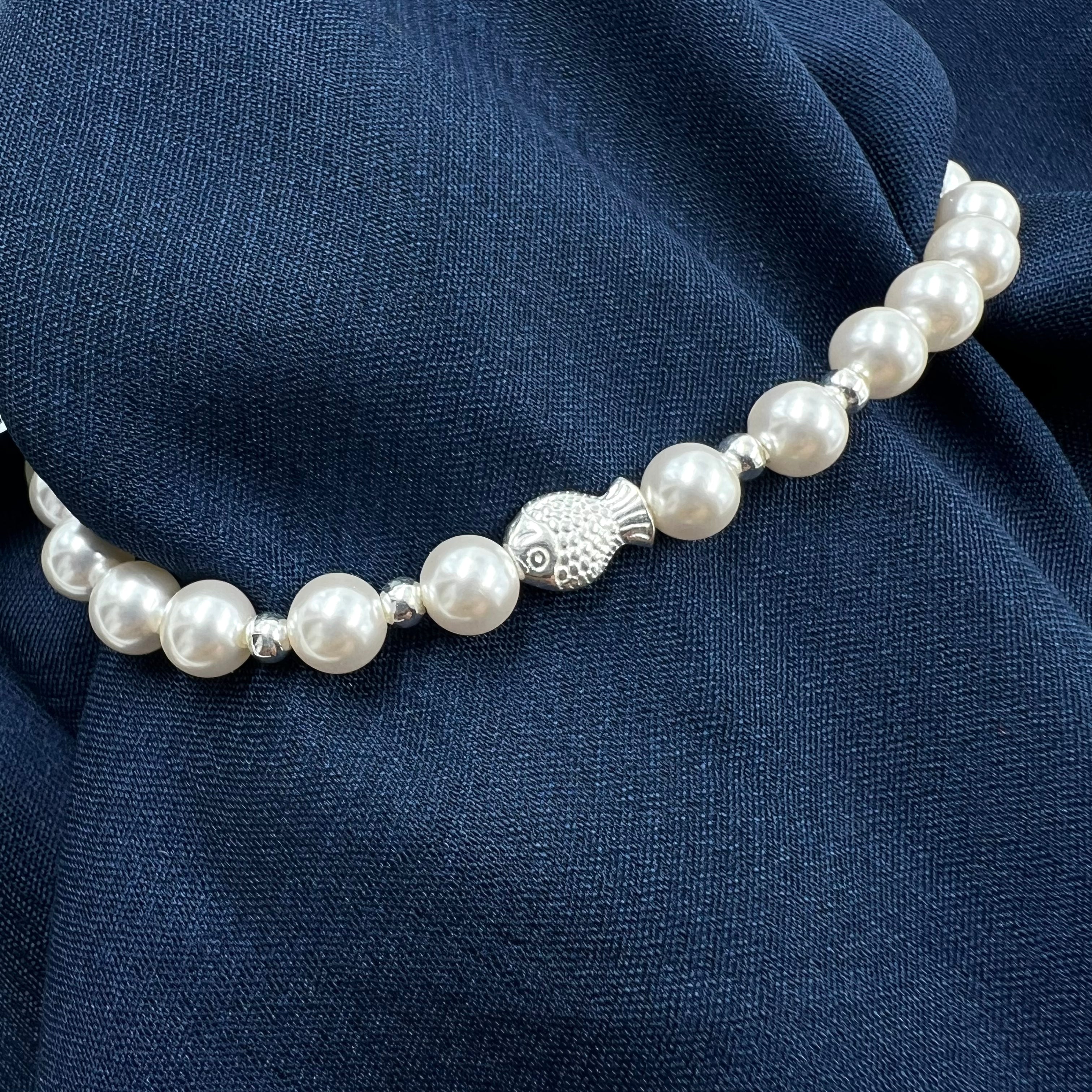 Pearl necklace with a silver fish-shaped bracelet