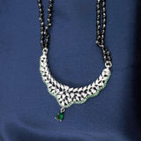 black bead mangalsutra chain with silver cz pendant and green stone drop.